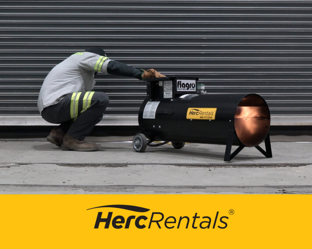 An employee safely starts a Herc Rentals direct fired heater outside a worksite.