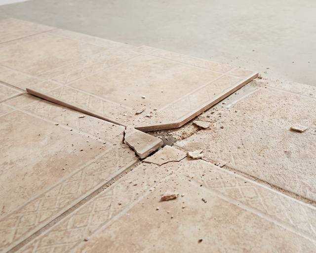 An image depicts broken tiles during the tile flooring removal process.