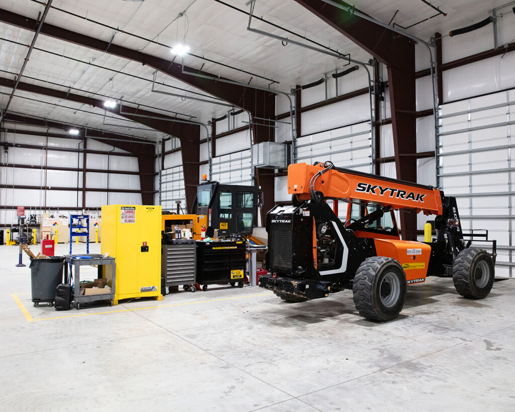 Herc Rentals technicians perform winter equipment maintenance inside a clean, orderly shop.