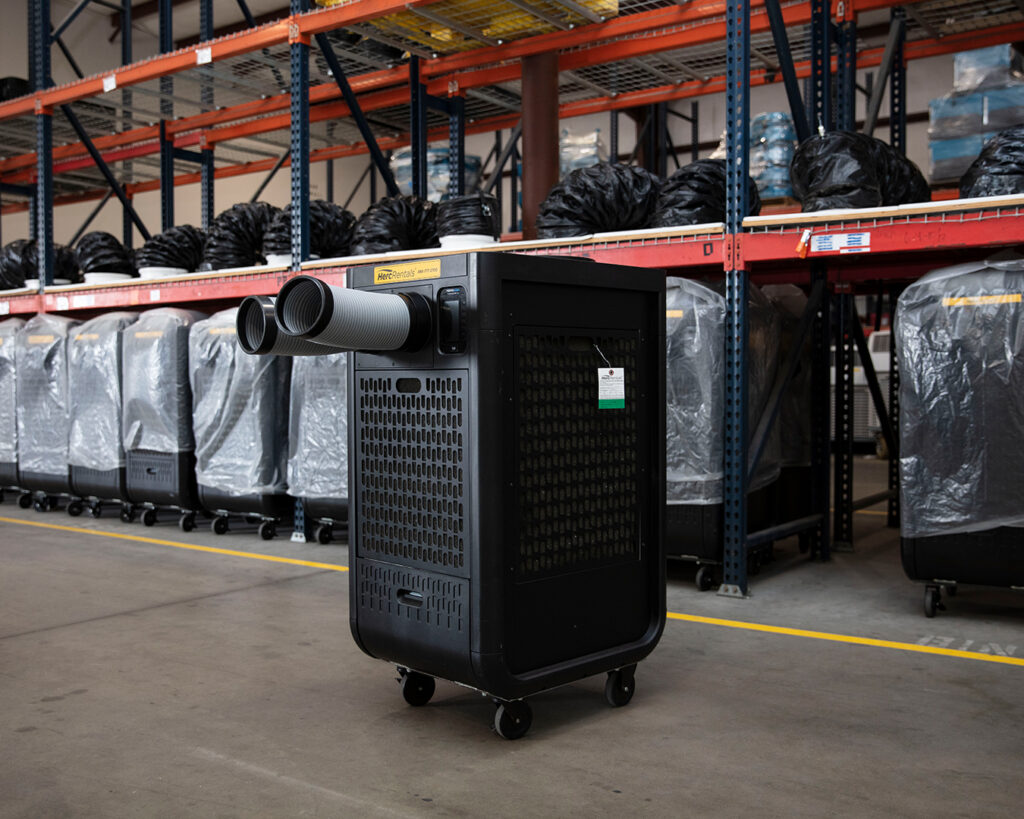 A portable AC unit is pictured in a warehouse as readers learn how climate control helps improve warehouse energy efficiency.