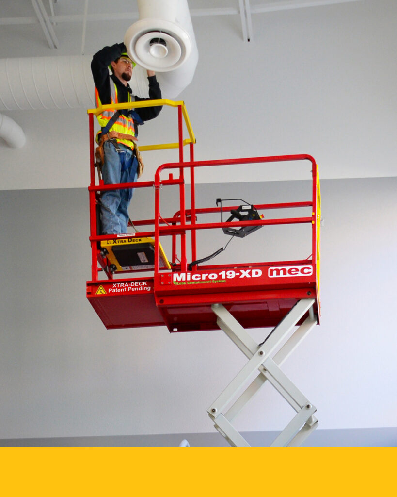 An employee works on a scissor lift with proper PPE, which is an important safety tips for data center workers. 
