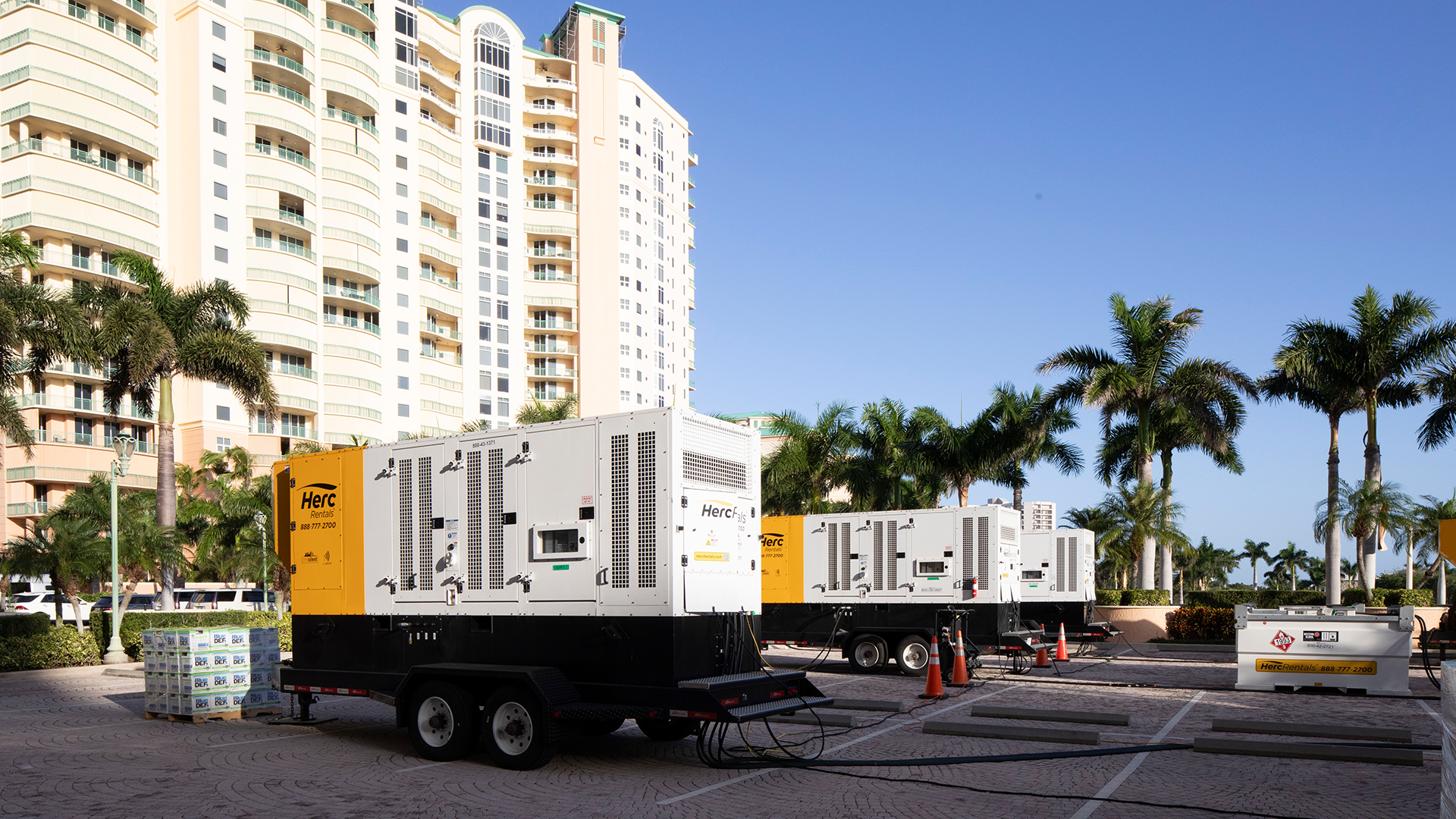 During a worksite power outage, a large Herc Rentals generator powers a building.