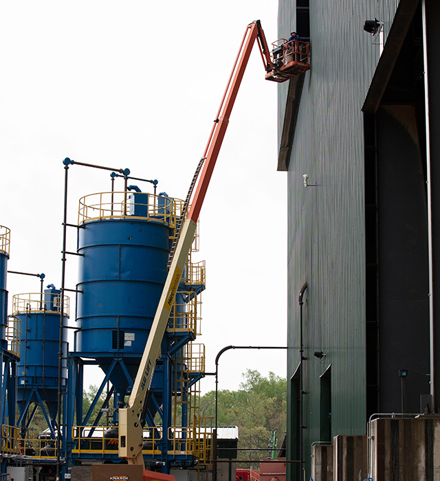 A boom lift is in use on an industrial construction jobsite. 